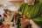 person in green long sleeve shirt holding clear drinking glass