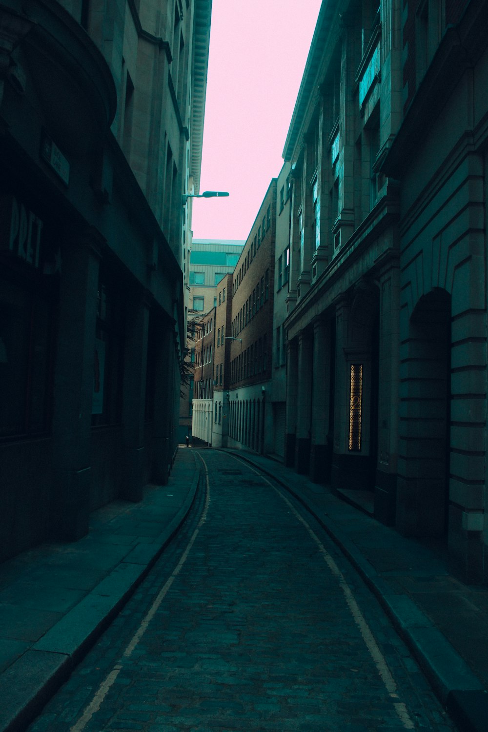 empty street between concrete buildings during daytime