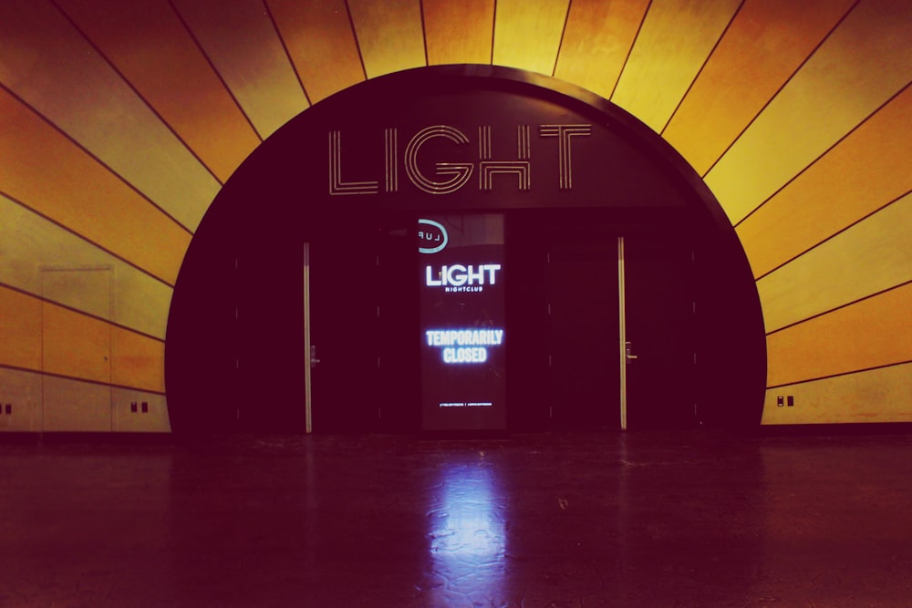 the entrance to a building that has a light sign on it