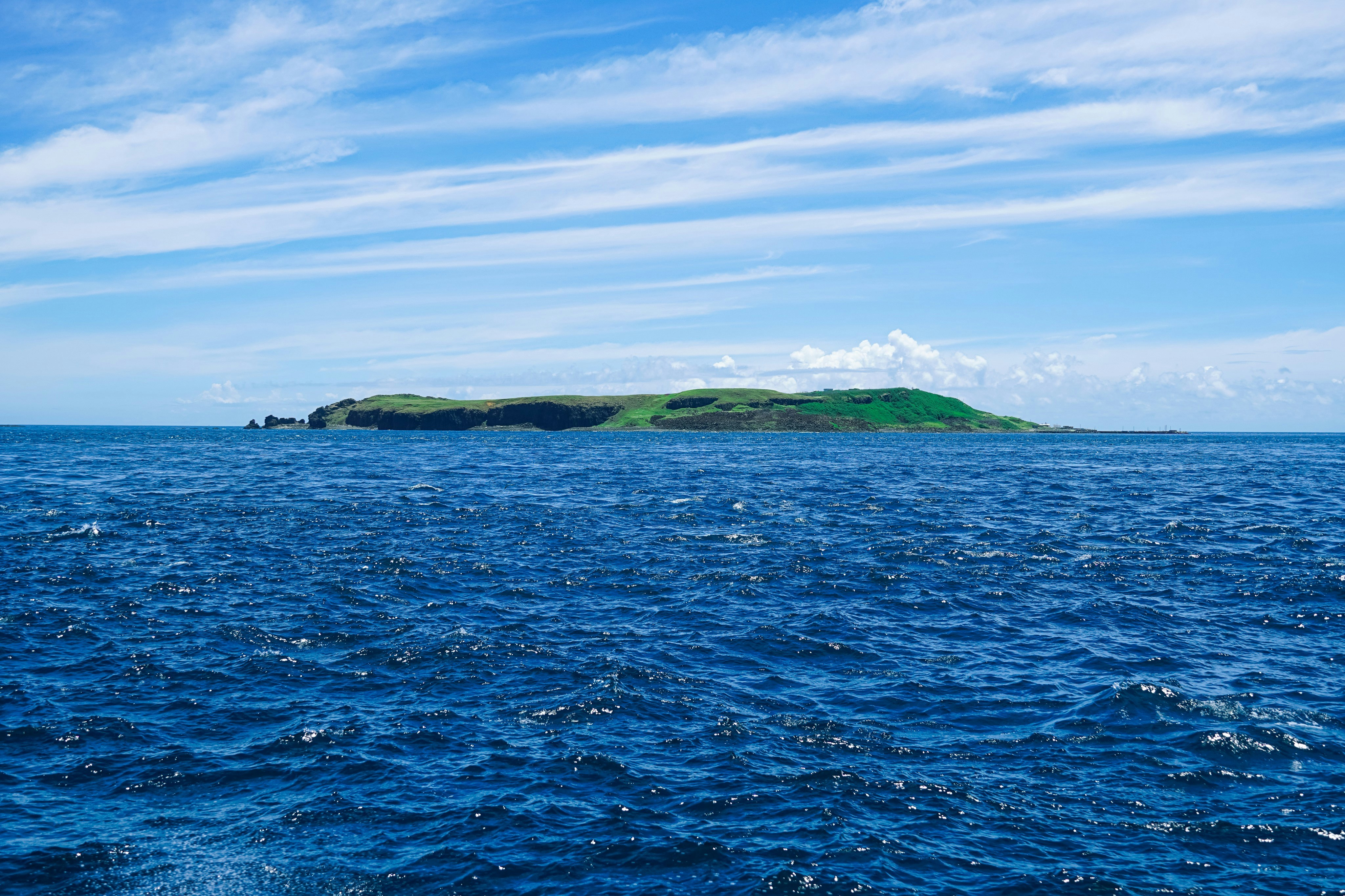 green and brown island under blue sky during daytime, 