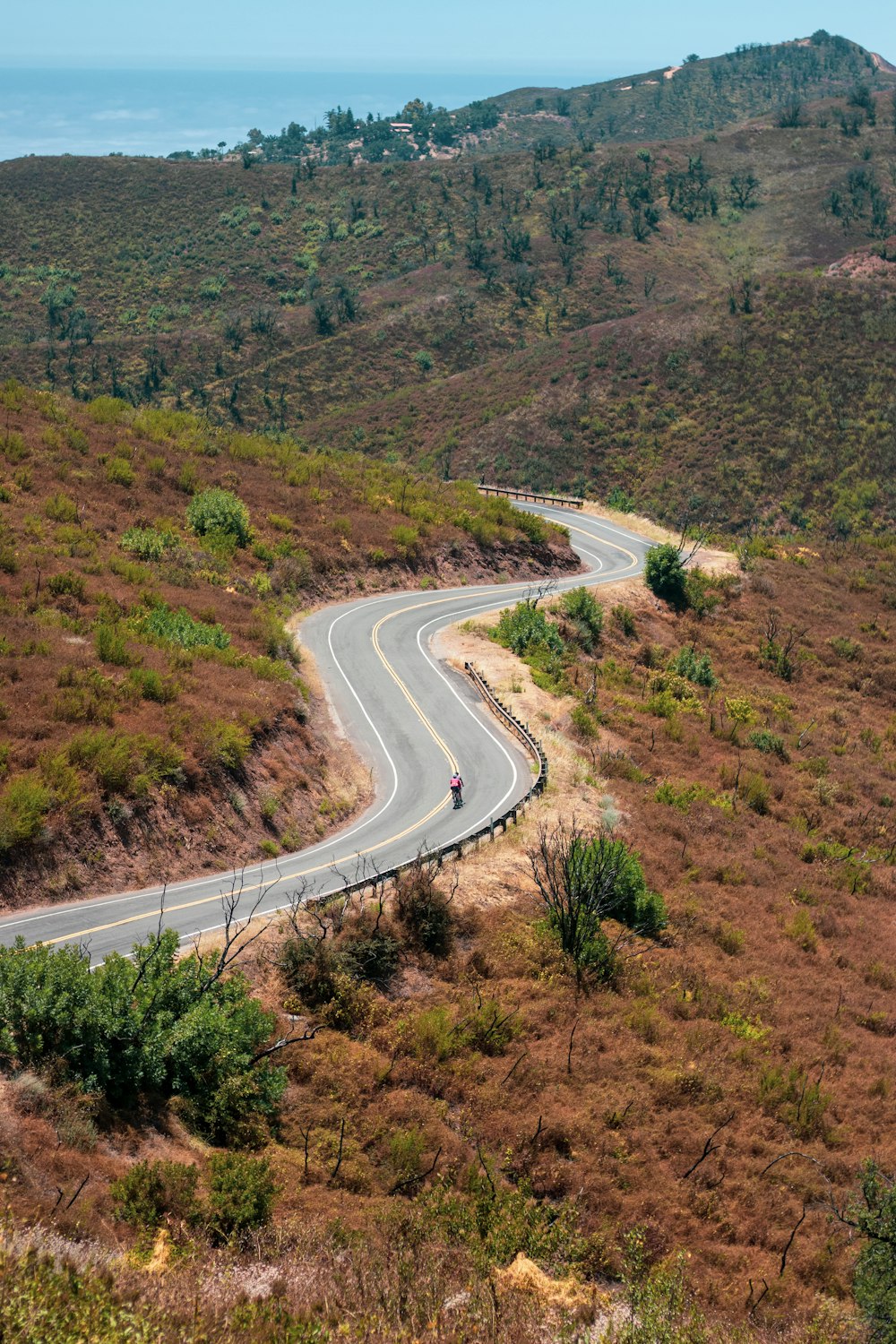 aerial view of road in the middle of green grass field