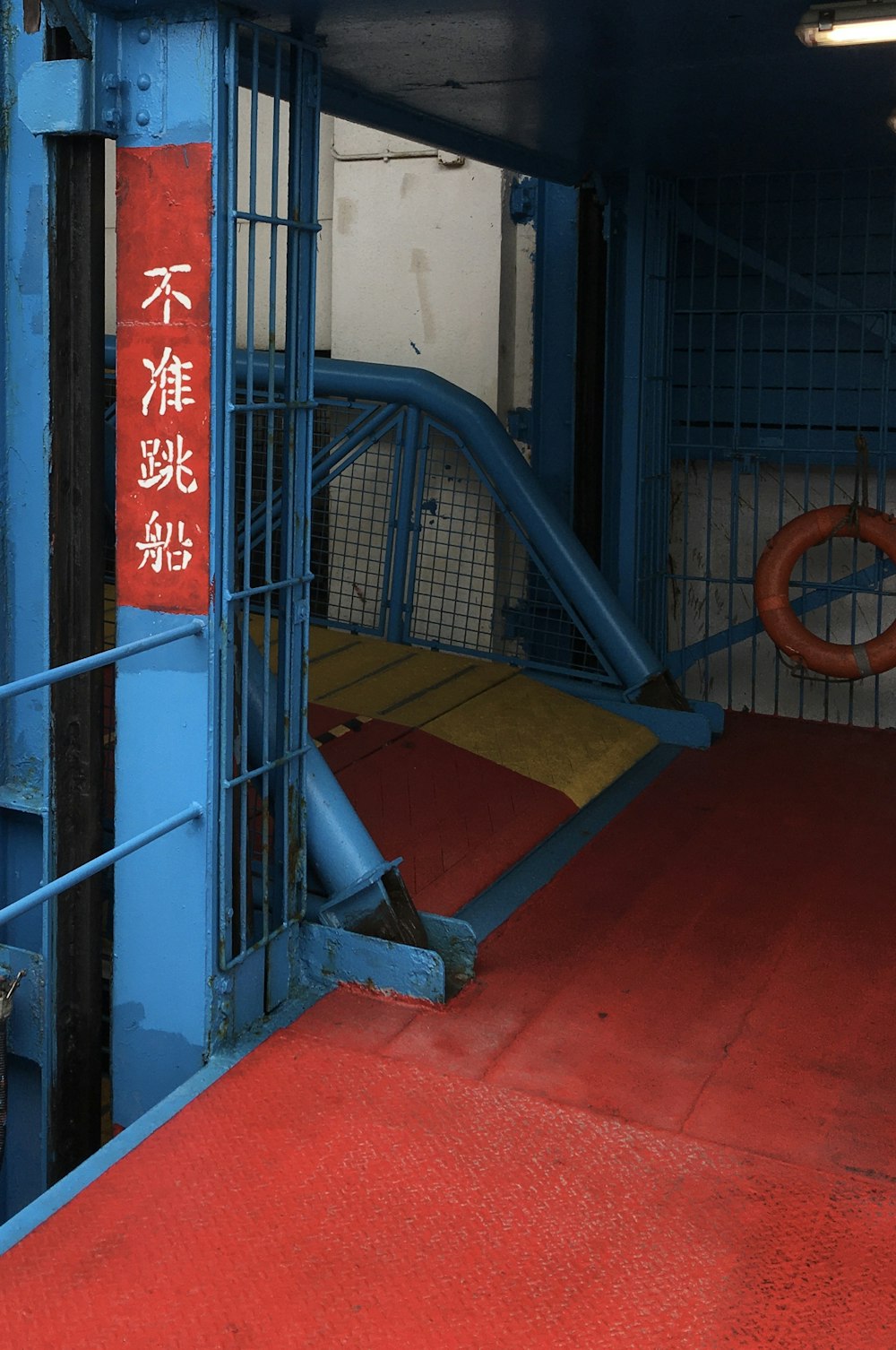 Escalera de metal azul sobre piso rojo