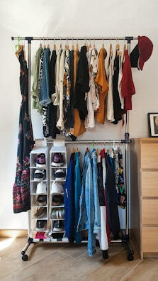 High-capacity multi-tiered wooden shoe rack filled with family shoes in a bedroom.