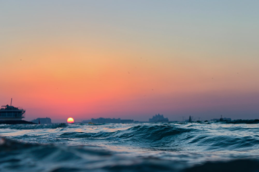 日没時のオレンジ色の空の下での海の波