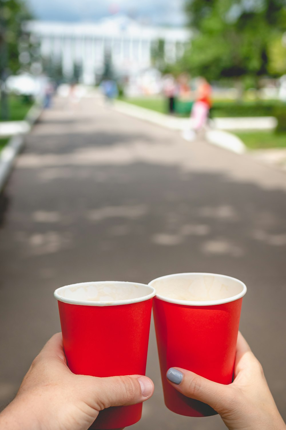 Persona sosteniendo vasos desechables rojos y blancos