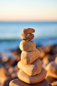 stack of stones near body of water during daytime