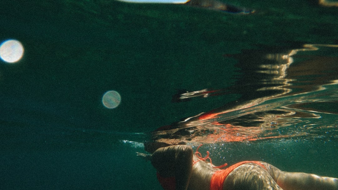 person in red and white shorts swimming under water