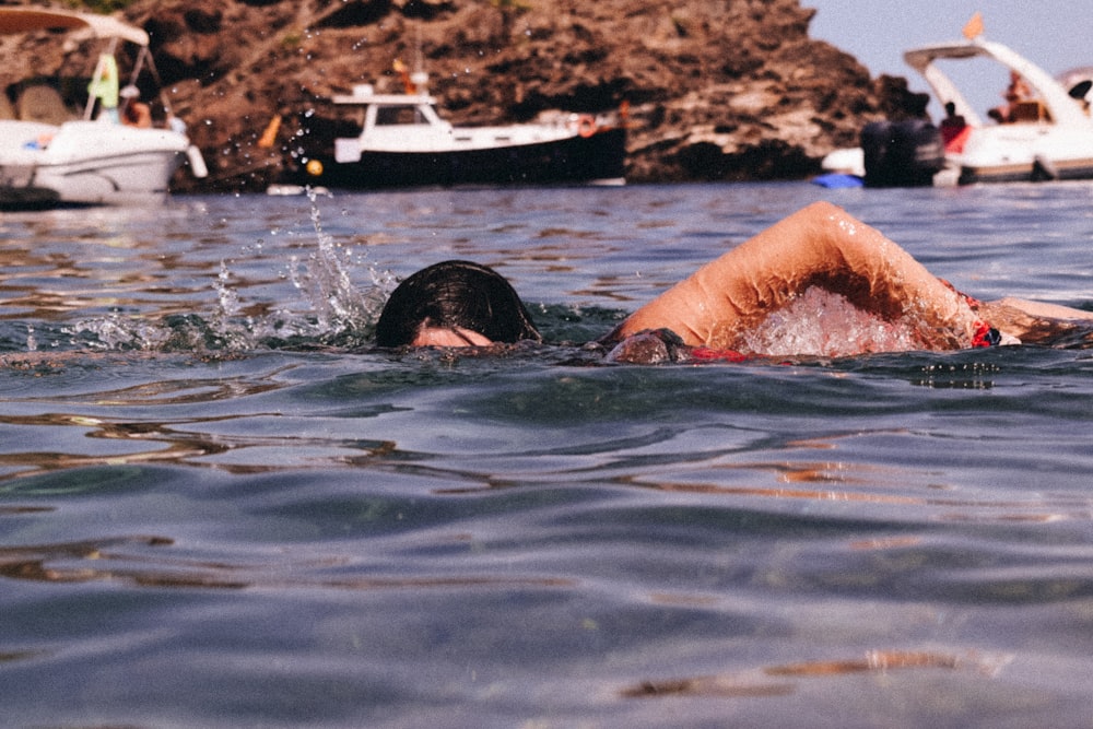 mujer en gafas de natación negras en el agua durante el día