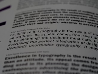 A close-up of a printed page showing text in different fonts and sizes. The visible text discusses typography, mentioning elements like attitude, planning, and the integration of design. The focus is on one sentence and the text around it is blurred.