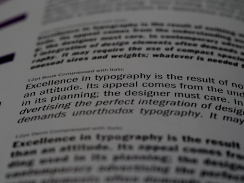 A close-up of a printed page showing text in different fonts and sizes. The visible text discusses typography, mentioning elements like attitude, planning, and the integration of design. The focus is on one sentence and the text around it is blurred.