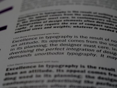 A close-up of a printed page showing text in different fonts and sizes. The visible text discusses typography, mentioning elements like attitude, planning, and the integration of design. The focus is on one sentence and the text around it is blurred.