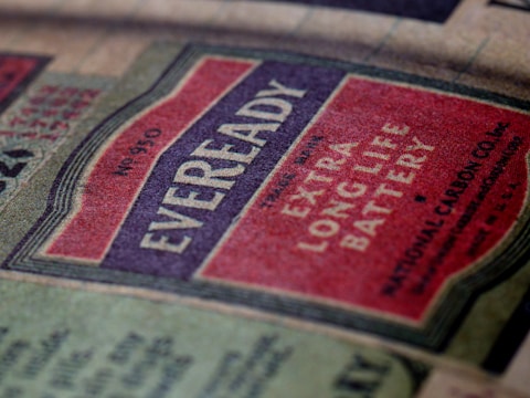 A vintage Eveready battery label featuring bold typography and a color scheme of red, off-white, and black. The label emphasizes the product's longevity with the words 'Extra Long Life Battery' prominently displayed. The texture of the paper gives a nostalgic feel.