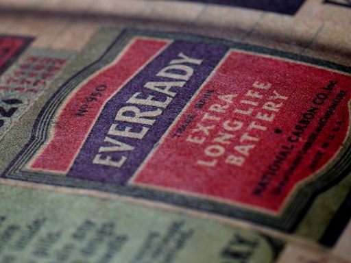 A vintage Eveready battery label featuring bold typography and a color scheme of red, off-white, and black. The label emphasizes the product's longevity with the words 'Extra Long Life Battery' prominently displayed. The texture of the paper gives a nostalgic feel.