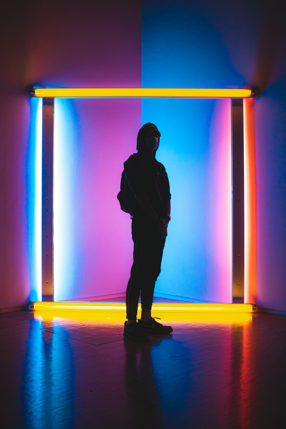 silhouette of man standing on blue and yellow floor