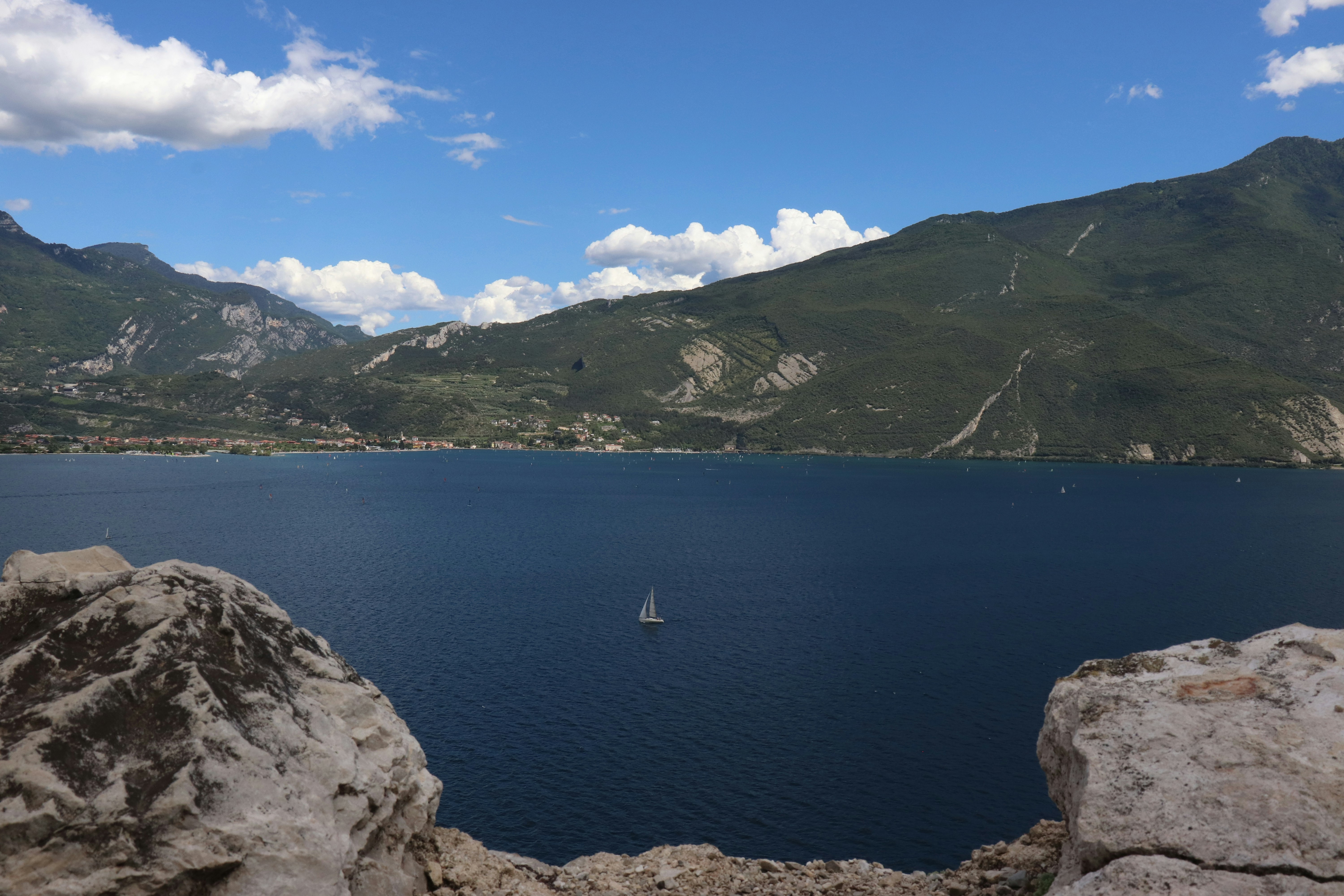 white boat on body of water near mountain during daytime