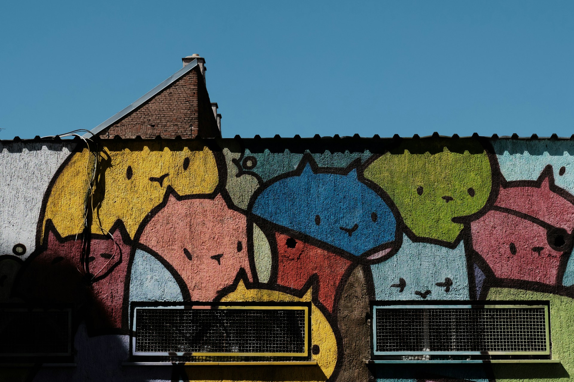 Children and adults painting vibrant cat-themed murals together at a lively community art event hosted by cincy cool cats.