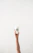 Close-up of a hand with perfectly done soft gel nails in a soft pastel shade, holding a minimalist beige coffee cup.