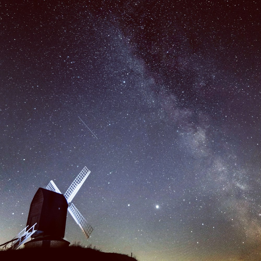 white and black windmill under starry night