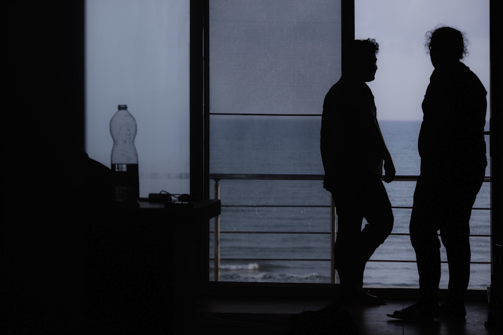 silhouette of man standing near window