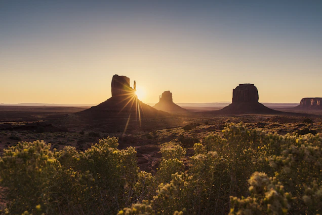 Sunset over the red rock formations surrounding the Gameleira retreat center, with soft desert light casting long shadows.