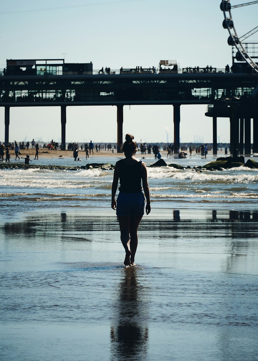 woman in black dress standing on seashore during daytime