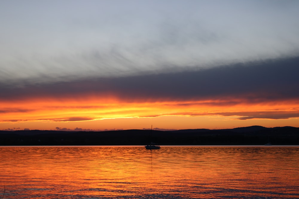 silhouette of boat on sea during sunset