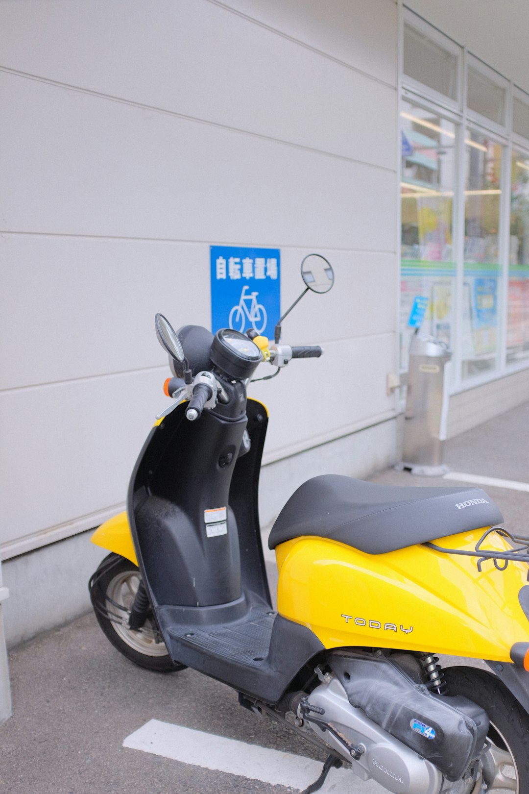 yellow and black motor scooter parked beside white wall