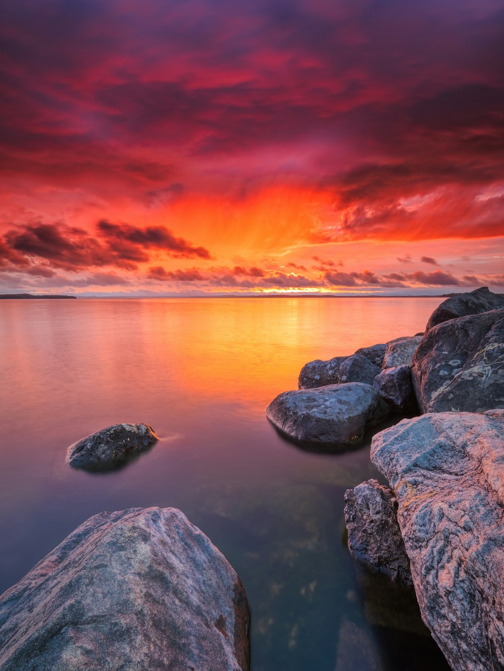 gray rocks on body of water during sunset