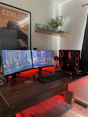 black flat screen computer monitor on brown wooden desk