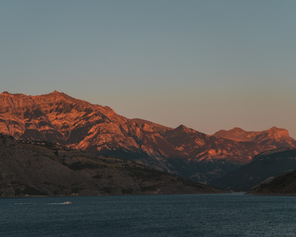 brown mountains near body of water during daytime