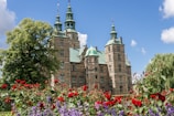 A historic castle surrounded by blooming gardens.