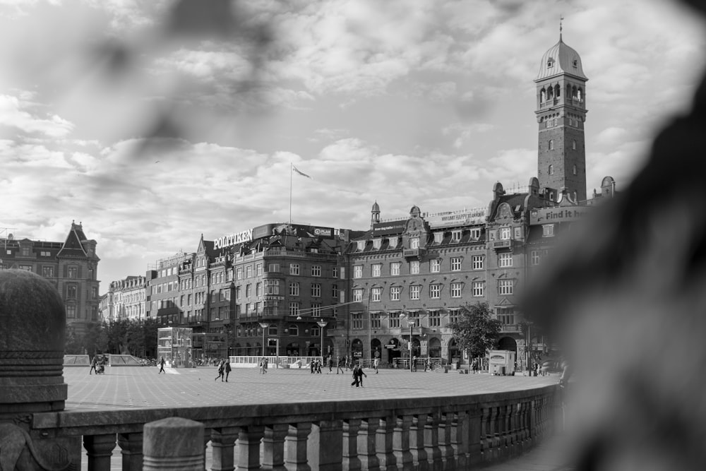 grayscale photo of people walking on street near buildings