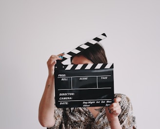 a woman holding a clapper over her face