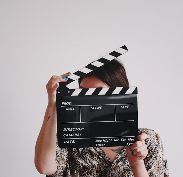 a woman holding a clapper over her face