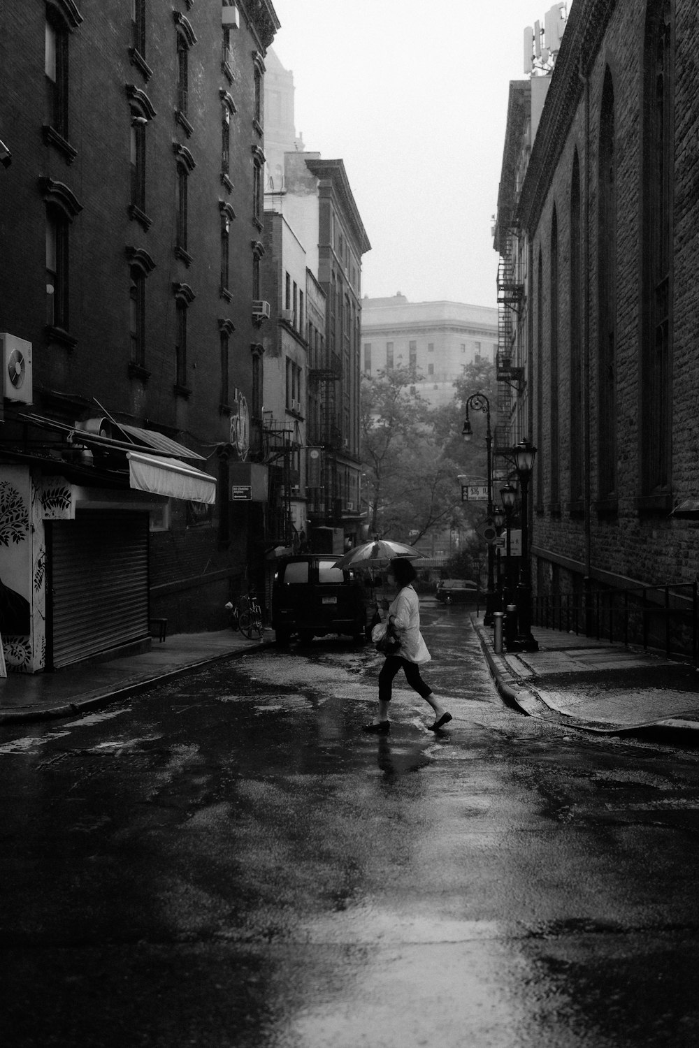 Foto en escala de grises de un hombre caminando por la calle