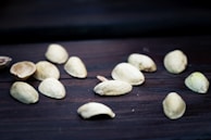 Freshly picked pistachios still in their shells, laid out on a traditional Afghan patterned fabric.