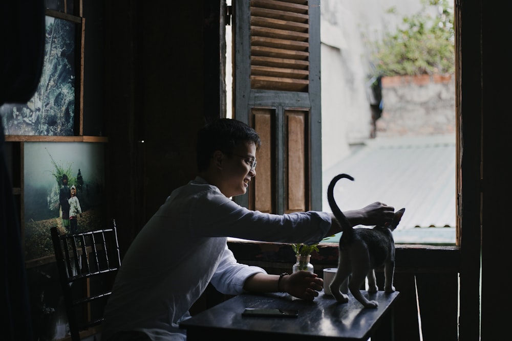 회색 긴팔 셔츠를 입은 남자가 의자에 앉아 있다