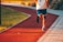 A person wearing sportswear while jogging outdoors in the sunlight.