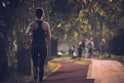 woman in black tank top and black pants walking on sidewalk during daytime