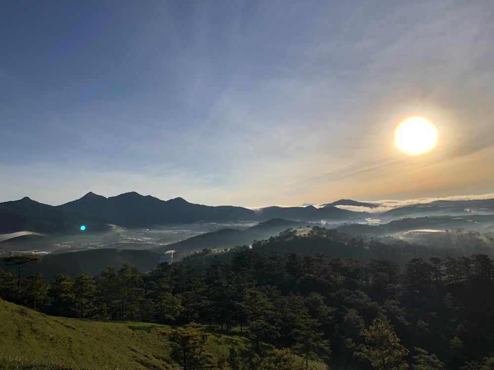 日の出の緑の木々と山々