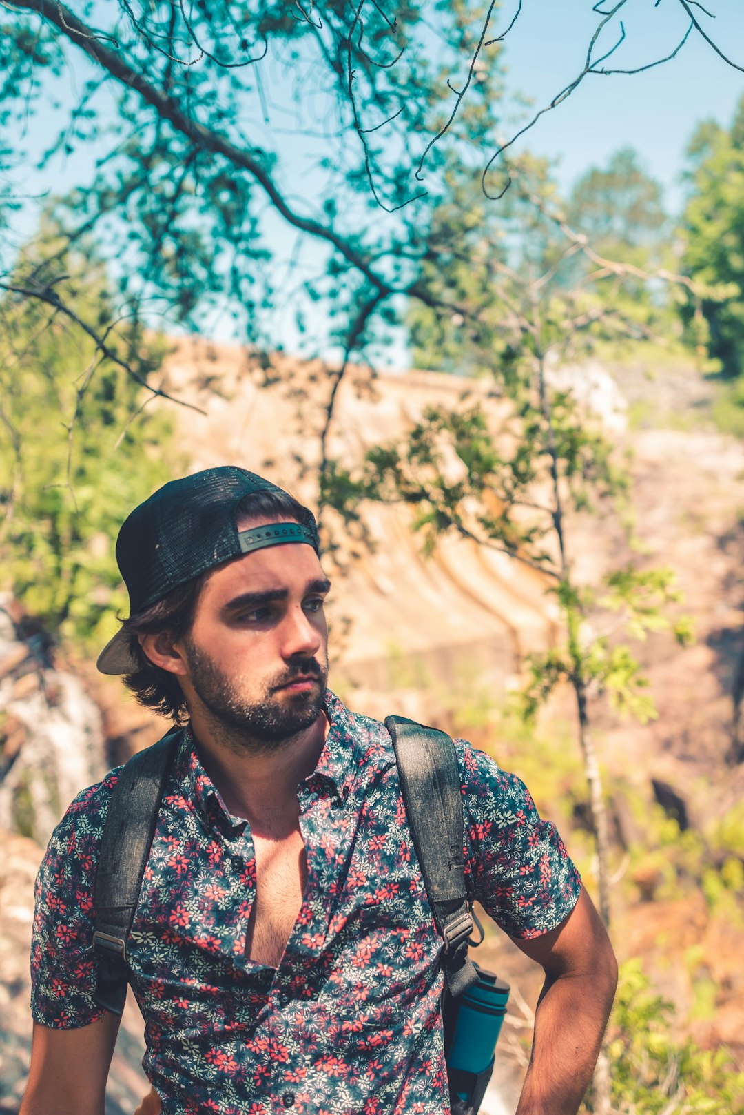 man in black and brown floral shirt wearing black cap