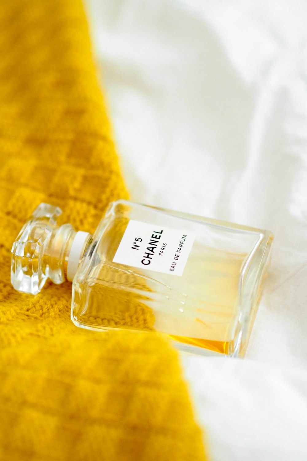 clear glass perfume bottle on white textile