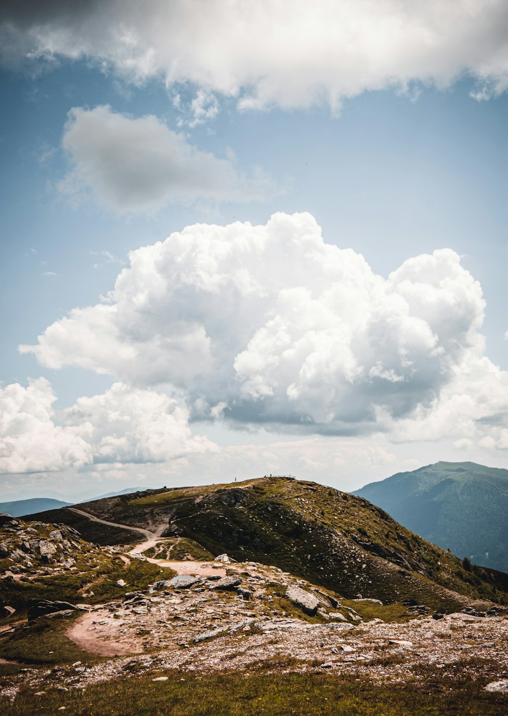 brown and green mountain under white clouds and blue sky during daytime