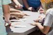 A family gathered around a table solving a colorful puzzle together, smiles and focus on their faces