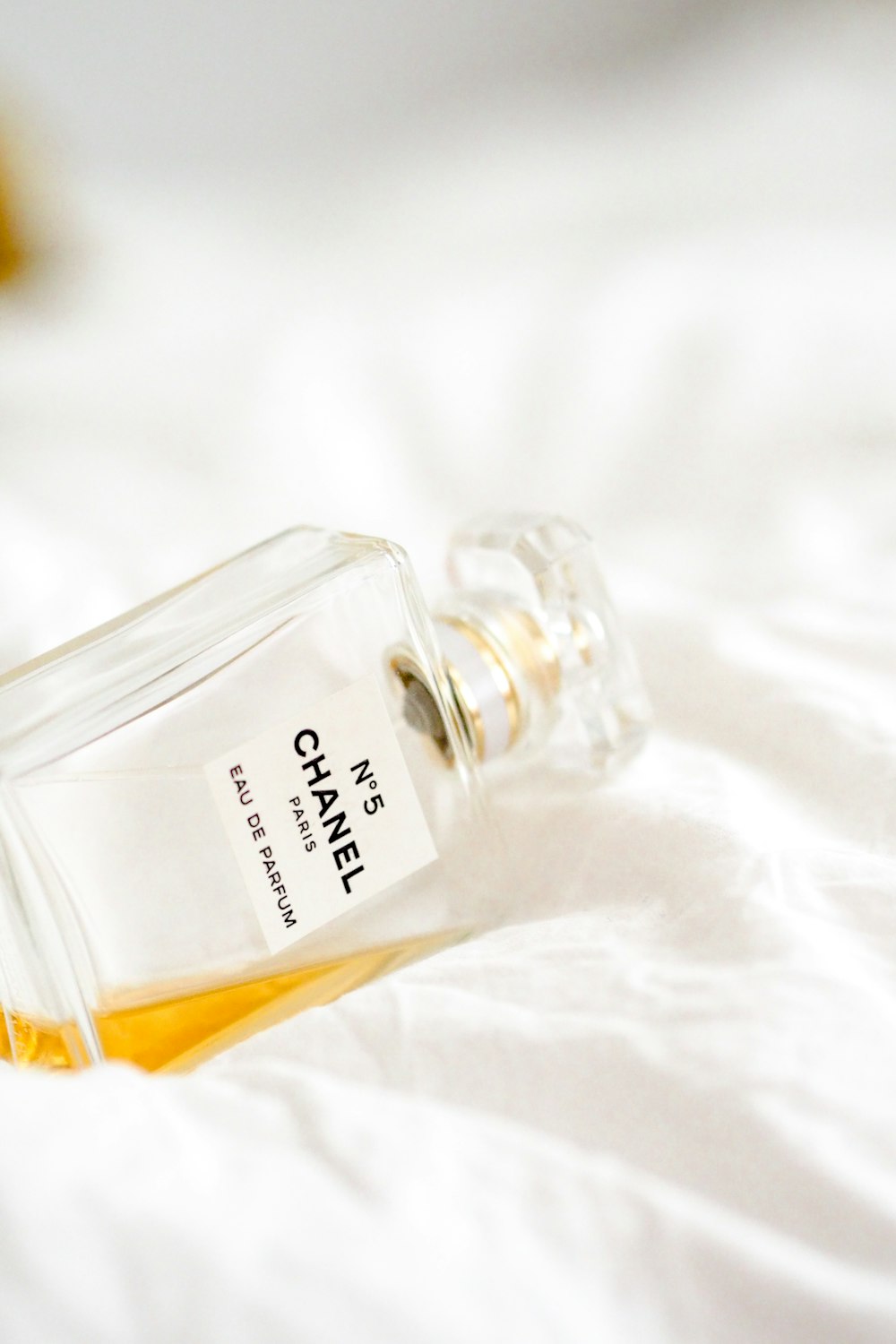 clear glass perfume bottle on white textile