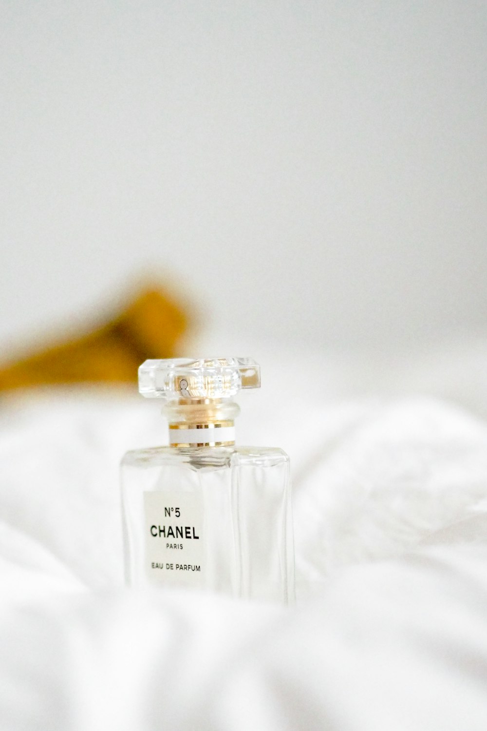 a bottle of chanel perfume sitting on a bed