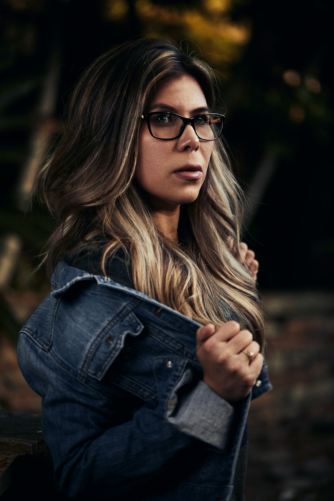 woman in blue denim jacket wearing black framed eyeglasses