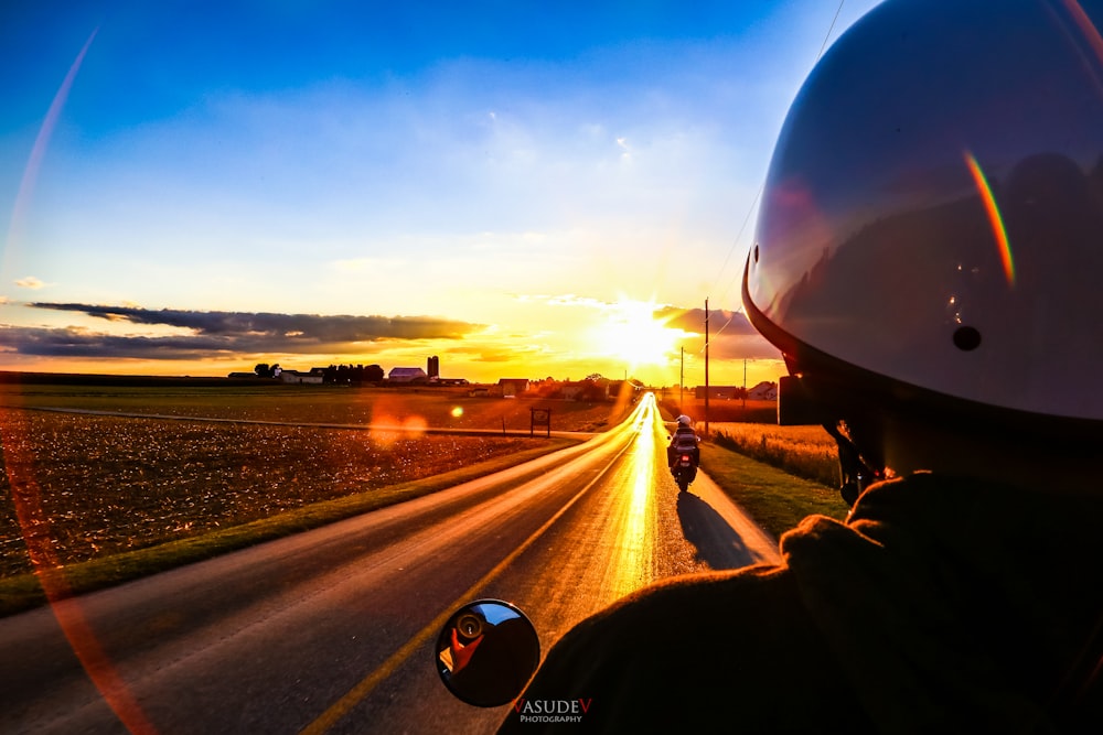 person driving car on road during sunset