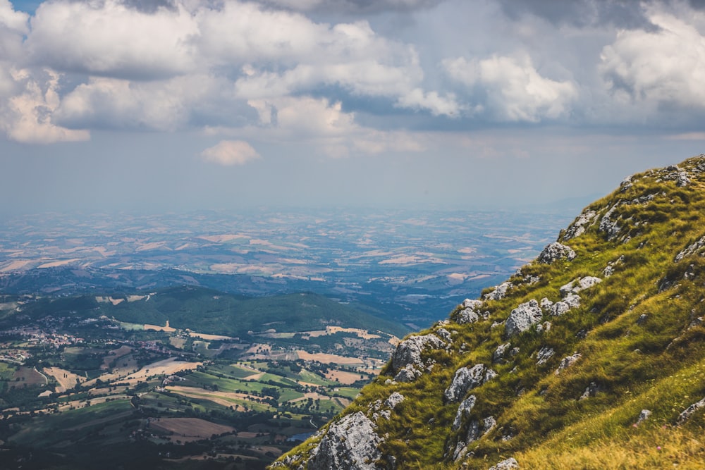 aerial view of green mountains under cloudy sky during daytime