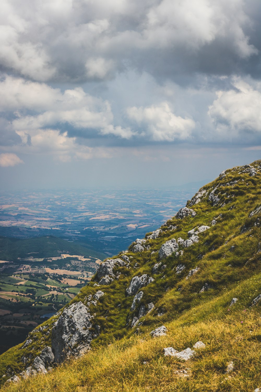 green grass covered mountain under white clouds during daytime